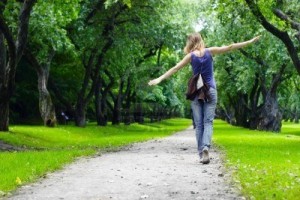 7888887-woman-walking-on-path-in-green-summer-park